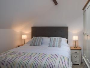 a bedroom with a white bed with two lamps at Derbys Loft in Beccles