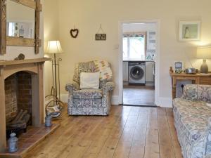 a living room with a fireplace and a chair at Eastwyn in Winterton-on-Sea