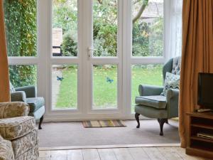 un soggiorno con due sedie e una grande finestra di Eastwyn a Winterton-on-Sea