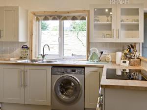 a kitchen with a sink and a washing machine at Eastwyn in Winterton-on-Sea