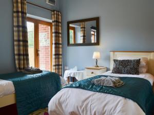 a bedroom with two beds and a mirror on the wall at The Stables in Martin
