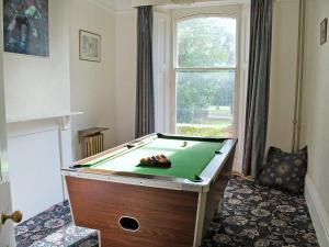 a pool table in a room with a window at Hill House in Melbourne