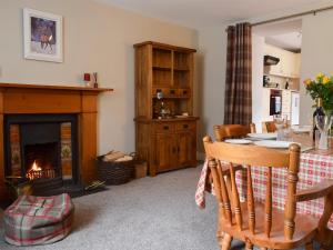 a living room with a table and a fireplace at Toadhall in Aberfeldy