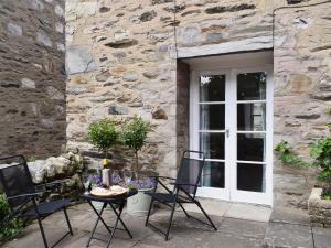 a patio with a table and chairs in front of a building at Toadhall in Aberfeldy