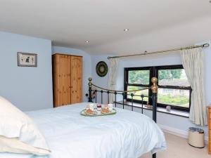 a bedroom with a bed with a tray of food on it at Lillegarth in Bradwell