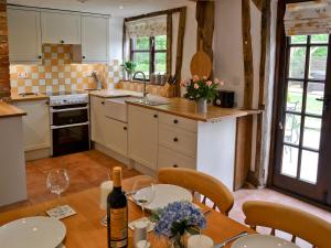 uma cozinha com uma mesa e uma garrafa de vinho em The Old Stables em Rickinghall