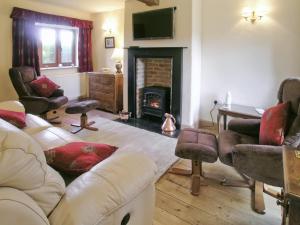 a living room with a couch and a fireplace at Two Bridge Cottage in Winsham