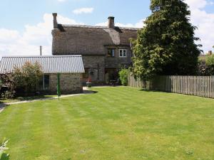 an old stone house with a large yard at Two Bridge Cottage in Winsham