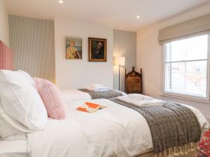 1 dormitorio con 2 camas y ventana en Collett House, en Southwold