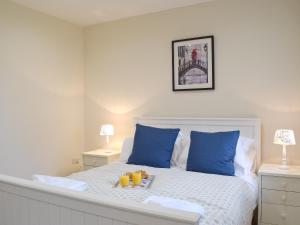 サンダースフットにあるSouthlands Barnのベッド(青い枕、オレンジのトレイ付)