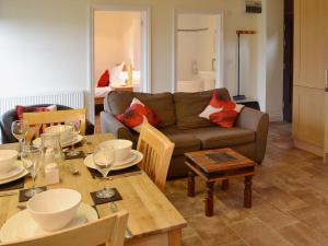 a living room with a couch and a table at The Haybarn in High Halstow