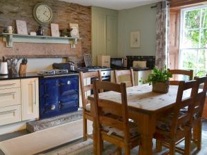 a kitchen with a wooden table and a blue stove at North Coombe Farm in Upton