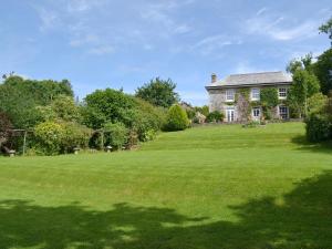 a house with a large green lawn in front of it at North Coombe Farm in Upton