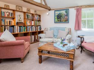 sala de estar con 2 sillas y mesa de centro en Pheasants Hill Old Byre, en Hambleden