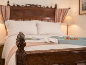 a bedroom with a bed with a wooden head board at Pheasants Hill Old Byre in Hambleden