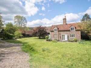 an old brick house with a grass yard at Pheasants Hill Old Byre in Hambleden