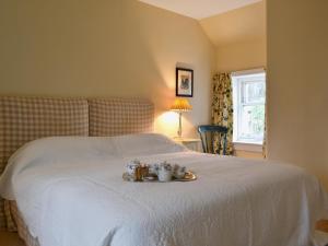 a bed with a tray with cups and mugs on it at Old Inzievar in Blairhall