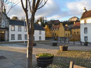 a town square with a tree and buildings at Old Inzievar in Blairhall