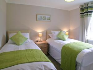 オーバンにあるKerrera Viewのベッドルーム1室(ベッド2台、緑と白のシーツ付)