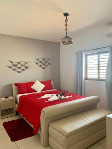 1 dormitorio con cama roja y manta roja en Casa dos Girassóis, en Pipa