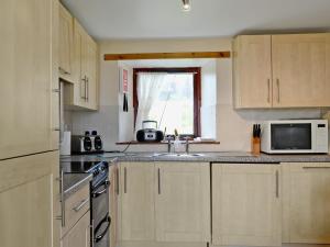 a kitchen with a sink and a microwave at Lochview in Milovaig