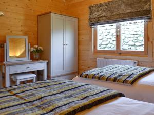 a bedroom with two beds and a desk and a window at Ty Pren in Dyffryn