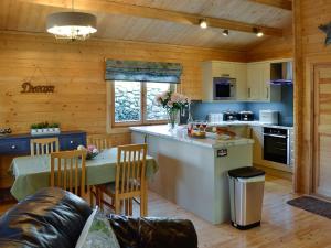 a kitchen and dining room with a table in a cabin at Ty Pren in Dyffryn
