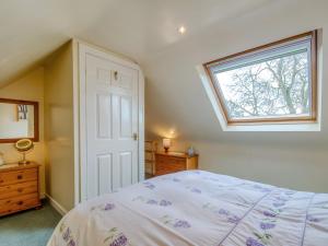 um quarto com uma cama e uma clarabóia em Blossom Cottage em Goldsborough