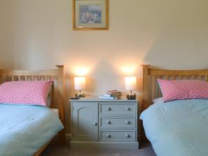 1 dormitorio con 2 camas y mesita de noche con 2 lámparas en Poplar Bungalow, en Lyng
