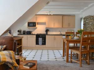 a kitchen and living room with a table and chairs at Willow Cottage in Woolfardisworthy