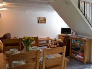 a living room with a table and a couch at Willow Cottage in Woolfardisworthy