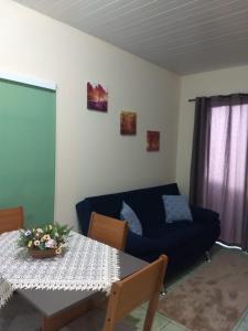 uma sala de estar com um sofá azul e uma mesa em Casa Bromélia 2 em Pomerode