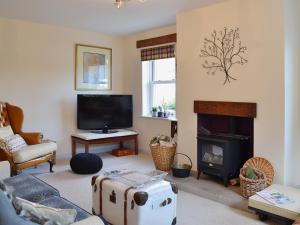 a living room with a couch and a fireplace at Lilac Cottage in Redmire