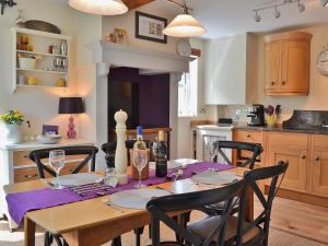 a kitchen with a table with a purple table cloth at Lilac Cottage in Redmire