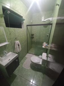 uma casa de banho com um chuveiro, um WC e um lavatório. em Casa Bromélia 2 em Pomerode