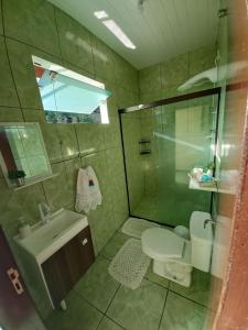 uma casa de banho com um chuveiro, um WC e um lavatório. em Casa Bromélia 2 em Pomerode