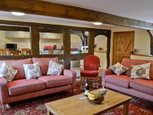 a living room with two couches and a table at Mill Cottage in Peterchurch