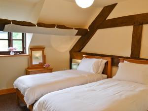 two beds in a room with a roof at Mill Cottage in Peterchurch