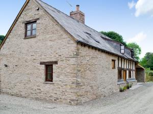 an old brick building with a roof at Mill Cottage in Peterchurch