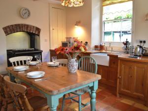a kitchen with a table with a vase of flowers on it at Ryecroft in Windermere