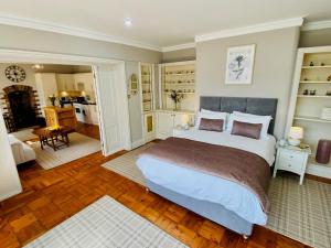 um quarto com uma cama grande e uma sala de estar em The Garden Rooms em Corbridge