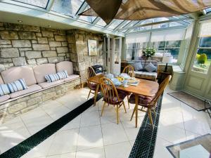 a conservatory with a table and chairs and a couch at The Garden Rooms in Corbridge