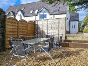 a table and chairs in front of a fence at Eryri in Caeathro