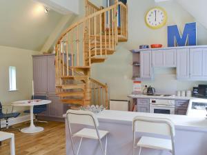 a kitchen with a spiral staircase and a table and chairs at The Gatehouse - Mvx in Belsay