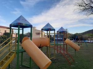 a playground with three slides and a slide at Complejo Mirador de las Sierras pileta climatizada al aire libre in San Javier