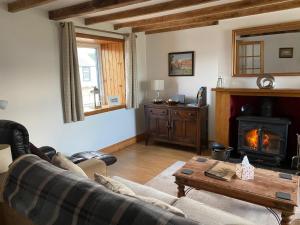 a living room with a couch and a wood stove at Iona Cottage in Clarencefield
