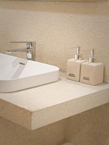 a bathroom counter with a sink and two soap dispensers at Lều Vịt Homestay Hải Phòng in Hạ Lý +63 photos