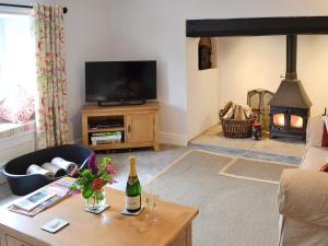 a living room with a table with a bottle of wine at Dairy House Farm in Hatch Beauchamp