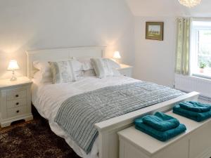 a bedroom with a white bed with two blue pillows at Dairy House Farm in Hatch Beauchamp