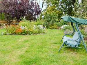 a chair sitting in the grass in a garden at Dairy House Farm in Hatch Beauchamp